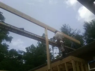 Carpenter setting a ridge beam over a new addition frame — Ice Dam Removal by Roofing Brothers in Burr Oak