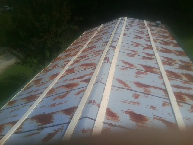Rusted metal roof panels with new wood purlins before replacement — Storm Damage Roof Repair in Burr Oak by Roofing Brothers
