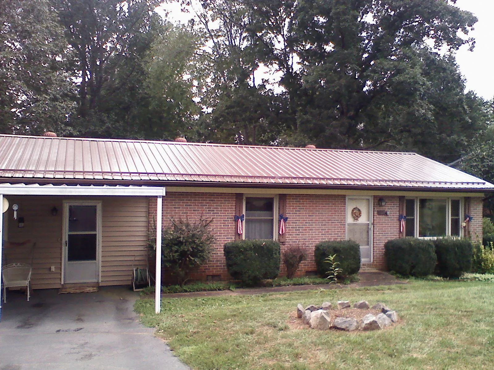 Bronze metal roof and carport on a brick ranch home — Roof Repair work by our crew in Burr Oak