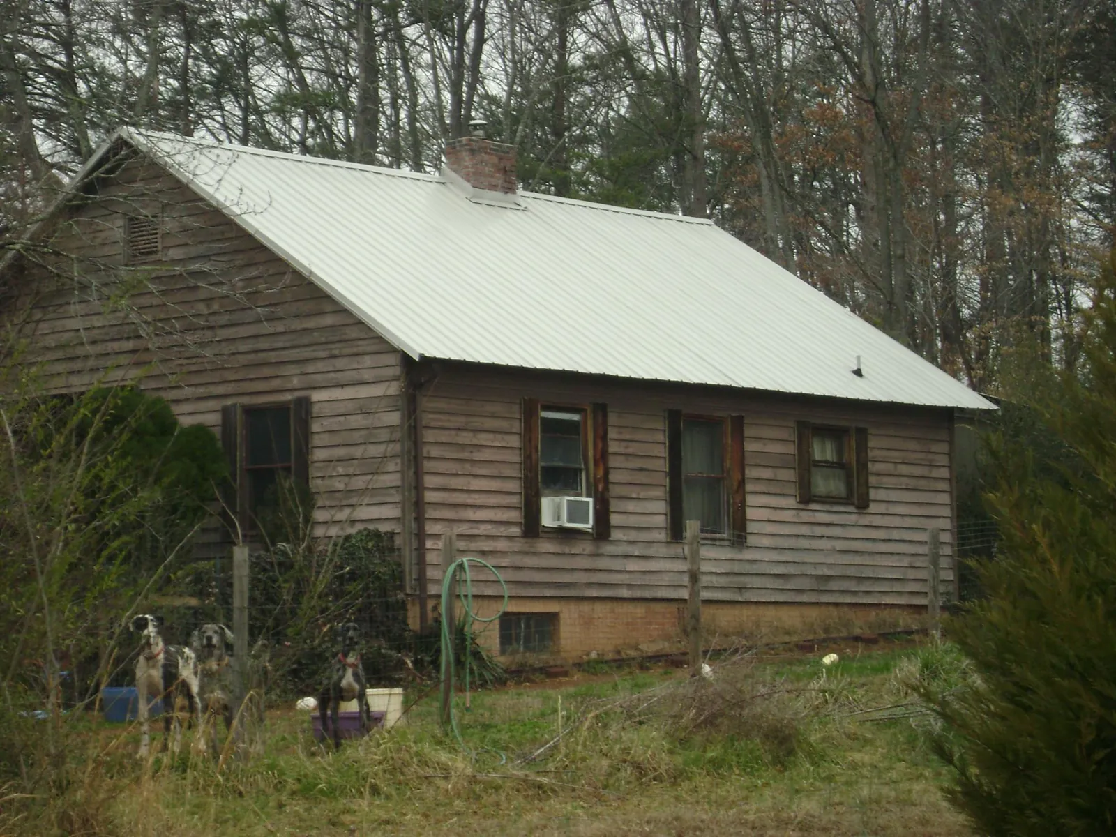 White metal roof on an old wood sided farmhouse, from a Metal Roof Installation job in Burr Oak